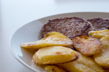 Piatto con hamburger e patate arrosto