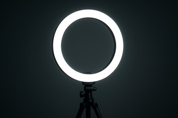 Ring light photography equipment studio LED lighting close up, professional circular lamp tripod stand dark background, modern content creator accessory videography illumination tool for beauty blogge