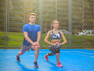 Obraz premium Young happy and focused couple doing exercises, fitness on city sports ground
