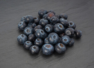 Blueberry on black plate. Fresh blue berry fruits, bilberry group on dark background