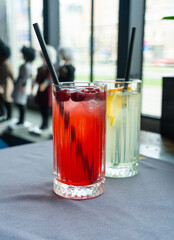 Cold lingonberry drink on restaurant table. Iced cowberry tea, refreshing cranberry cocktail