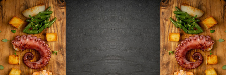 Grilled octopus tentacle on black stone plate served with shrimps © ange1011