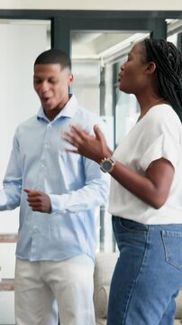 Vertical video: African American colleagues welcoming newcomer and clapping near sofa in lounge