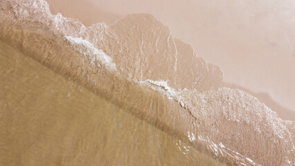 Coastal Serenity: Gentle waves caress the shore, forming intricate patterns in the sand. The sun's warm embrace bathes the scene in a soft, calming light, capturing the peace of a beach at dusk.