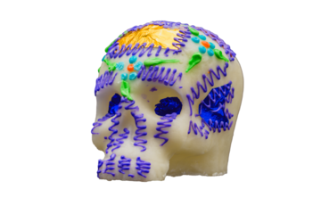 Colorful sugar skull decorated with purple icing and foil accents isolated