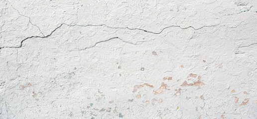 Obraz premium White concrete wall showing signs of age and cracking paint