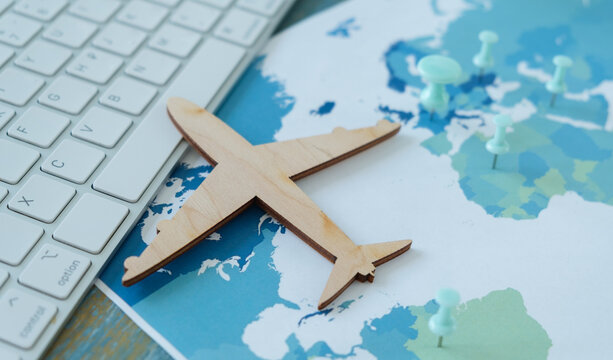 A wooden airplane is on top of a map of the world