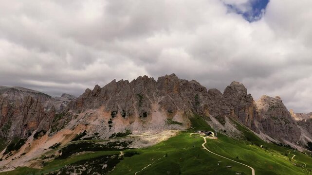A cinematic drone shot with a rotating camera reveals the dramatic Cirspitzen ridge in the Italian Dolomites