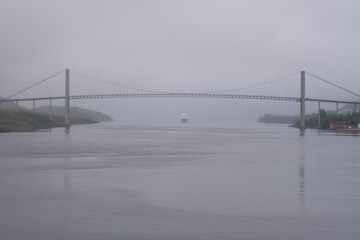 Cruise ship traveling under a suspension bridge