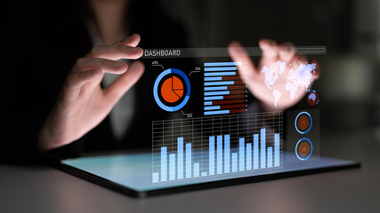 A businessman interacts with a futuristic digital dashboard on a tablet, showcasing vibrant data analytics and graphical representations in a modern workspace. Impute