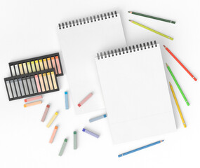 Blank spiral sketchbook surrounded by colorful pencils, pastel chalks, and pencil sharpeners on a white background. Artistic workspace concept. Suitable for drawing, sketching, creative design, educat