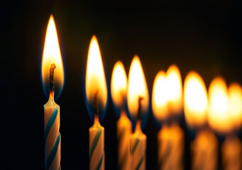 Burning Birthday Candles: Close-up of Flames Against Dark Background.