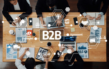 Obraz premium A dynamic business team collaborates in a modern meeting room, focusing on B2B strategies with charts and digital tools, enhancing productivity and decision-making. Amity