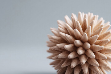 Macro shot of a spherical shape made of wooden toothpicks. Conceptual image for protection, defense, or even a metaphor for a virus. Clean, minimalist style.