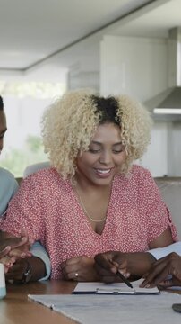 Vertical video: Advisor placing forms, couple signing, embracing and handshaking sealing agreement