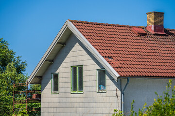 Closeup of gabled house with red tiled roof.