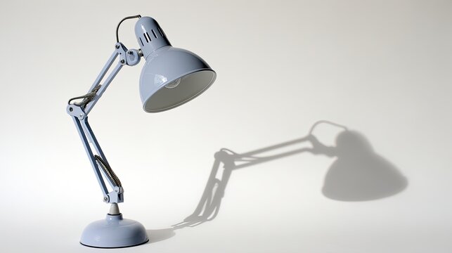 A Gray Metal Desk Lamp With Adjustable Arm Casts A Shadow On A White Background Minimalist Design For Modern Workspace