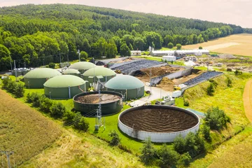 Biogas plant and farm in green fields. Renewable energy from biomass. Modern agriculture in Czech Republic and European Union.   © Kletr