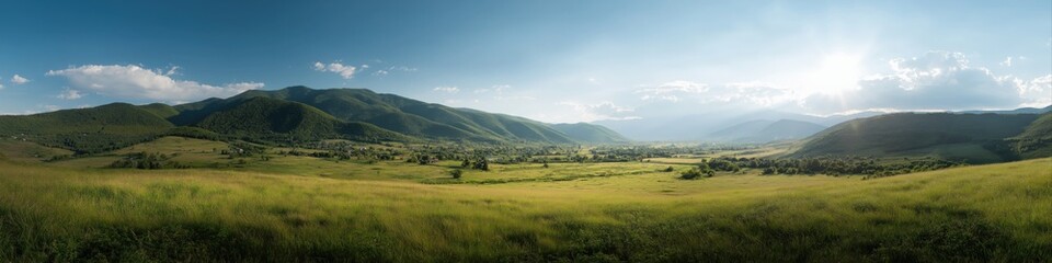 Scenic sunlit valley with green hills and clear blue sky