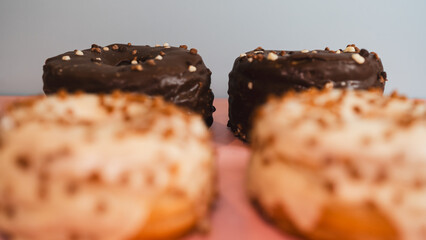 Extreme close-up of a chocolate donut and a white chocolate donut with salted caramel glaze, highlighting texture and decadent details. Perfect for food blogs, dessert menus, and social media content