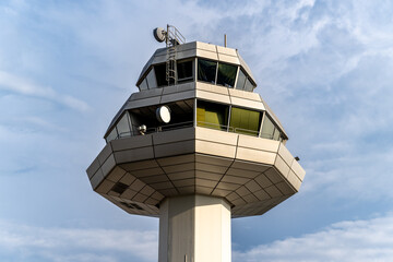 Modern Airport Control Tower Highlighted Against a Cloudy Sky During Rainy Weather