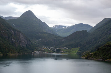 Views of famous Geirangerfjord in Norway, during cruise by ship. Buildings of Geiranger village on coast.