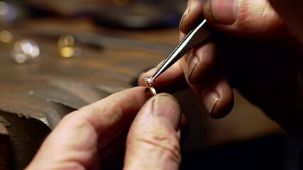 A skilled artisan carefully sets a diamond into a ring, showcasing the craftsmanship and luxury of fine jewelry.