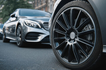 Modern vehicles parked on urban street showcasing sleek wheels and stylish design in daylight 
