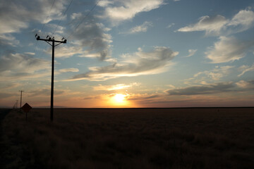 Obraz premium Cloudy sky on the background of sunset. The electric transmission line is visible on the left in the photo