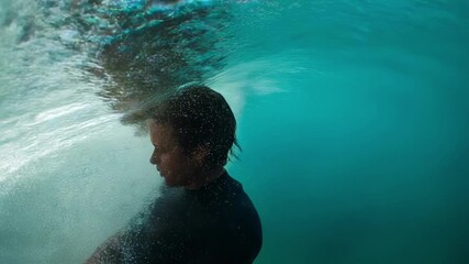 Professional surfer riding a powerful wave in the ocean under bright sunshine, embracing the excitement and challenges of the sport while showcasing impressive skill and balance