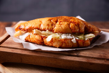 Pambazo. Sandwich marinated in guajillo chili sauce and roasted on a comal traditionally stuffed with potatoes and chorizo, a classic of Mexican street food.