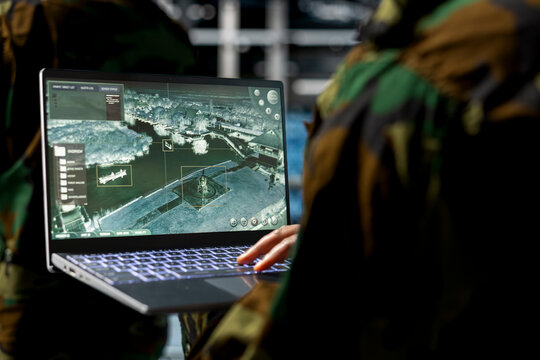 Close up of military technician in data center operating satellite control software from secure terminal. IT specialist monitoring orbital surveillance feeds in military server room