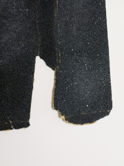 Close up of torn black sandpaper sheets on white background