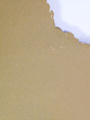Close up of torn brown textured paper revealing white background