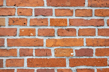 Red brick wall with visible mortar seams and rough texture. Straight-on view.