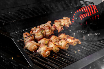 Grilled pork belly skewers cooking on barbecue grill