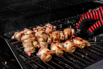 Grilled pork belly skewers cooking on barbecue grill