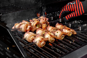 Grilled pork belly skewers cooking on barbecue grill