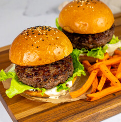 Grass-Fed Beef Burgers with Lettuce Wraps and Sweet Potato Fries on Wooden Board