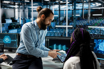 Team leader guides intern in data center to troubleshoot server connectivity issue using AI. Mentor teaches trainee during internship to audit systems for vulnerabilities using artificial intelligence