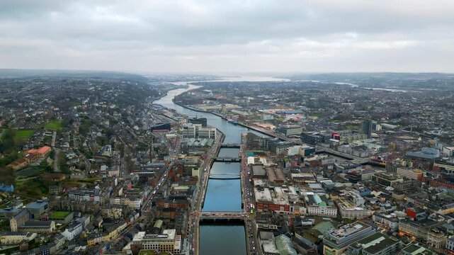 Aerial drone view of Cork City, Ireland, with the River Lee winding through the city center and multiple bridges connecting both sides
