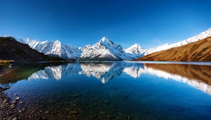 Obraz premium majestic snow capped mountains reflect in tranquil lake with clear water and blue sky