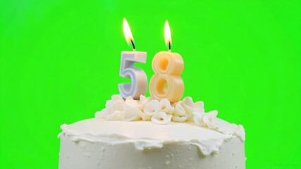 Celebrate milestone birthdays with flaming '58' candles atop a festive white cake, perfect for anniversaries and special occasions.