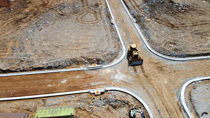 overhead drone shot of bulldozer at construction site