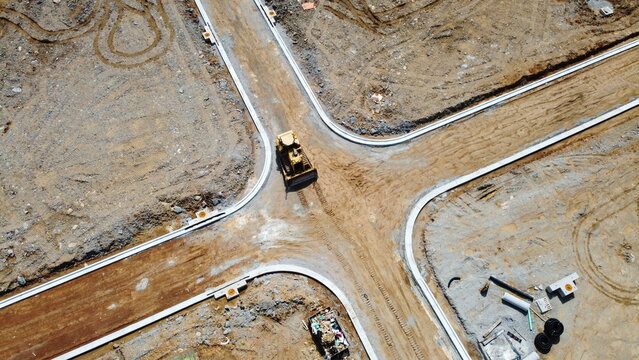 overhead drone shot of bulldozer at construction site
