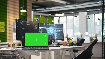 Fototapeta premium Chroma key notebook in AI industry startup workspace leveraging machine learning technology. Empty startup office with isolated screen laptop and artificial intelligence program running on monitors