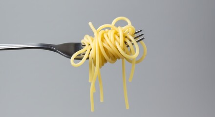 Golden Spaghetti Noodles Artfully Twirled on a Fork, Isolated on Gray