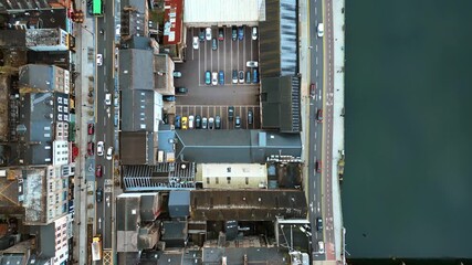 Aerial drone view of Cork's River Lee and its iconic bridges flowing through the city center, with dense architecture and traffic movement