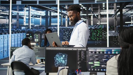 Fototapeta premium Data center engineer doing node tree programming to optimize resource allocation. Server farm specialist using predictive AI visualization systems for maintenance planning, camera A