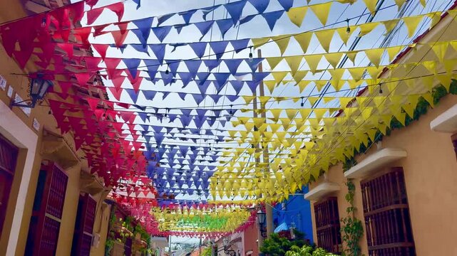 Colorful flags waving in the wind above a Colombian street in artistic Getsemani district